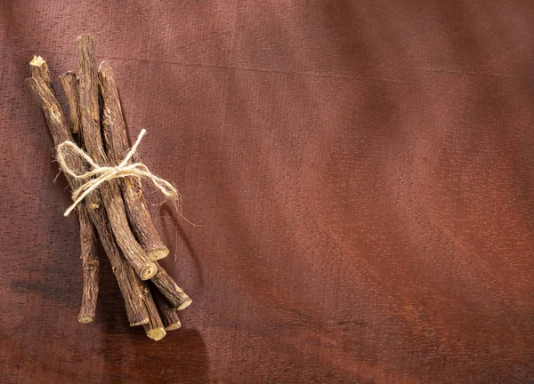 Licorice stems on the wooden background - Glycyrrhiza glabra — Stock Photo, Image