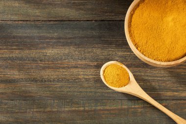 Organik zerdeçal tozu - Curcuma longa. Ahşap arka plan
