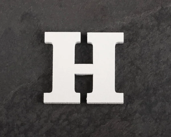Gri arka plandaki boş alfabeden H harfi - Üstteki görünüm — Stok fotoğraf