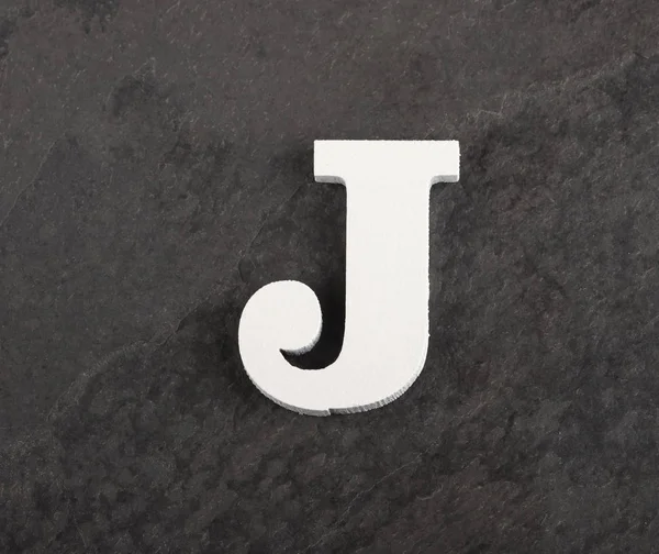 Gri arka plandaki boş alfabeden J harfi - Üstteki görünüm — Stok fotoğraf
