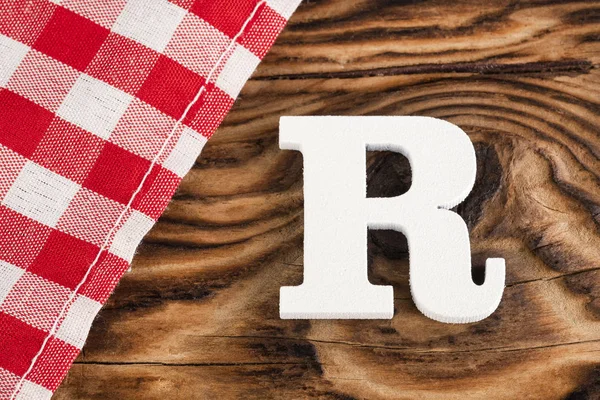 アルファベットの文字R - 素朴な木製の背景に赤いチェッカー布のテーブルクロス。テキストスペース — ストック写真