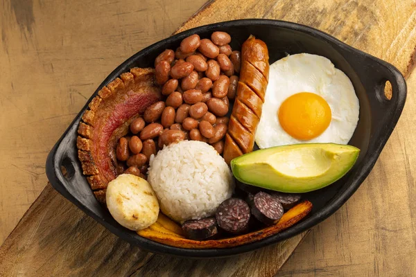 Bandeja paisa, plato típico de la región de Antioquena en Colombia. Consta de chicharrn (vientre de cerdo frito), budín negro, salchicha, arepa, frijoles, plátano frito, huevo de aguacate y arroz. —  Fotos de Stock