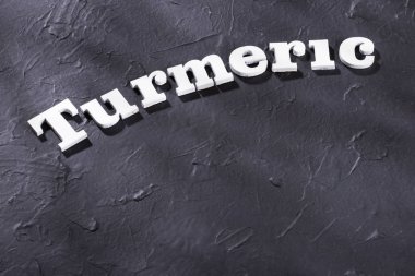 Tahta harflerle zerdeçal kelimesi - Curcuma longa. Metin alanı