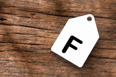 Tahta arkaplanda beyaz etiketli F harfi