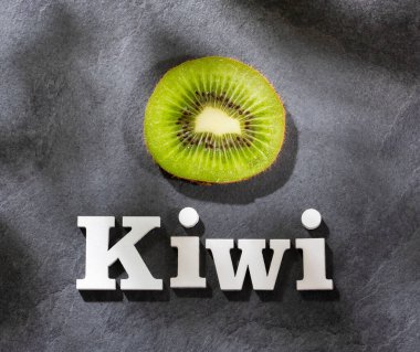 Kivi dilimleri ve beyaz harflerle kivi.