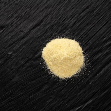 Koyu arkaplanda doğal organik buğday irmiği yığını