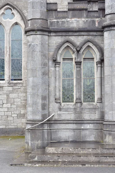 Arched windows with stained glass on stone early English style church in Ireland.