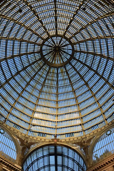 Detail of ceiling and cupola structure with glass panes and pair of angel statues of Galleria Umberto in Naples.