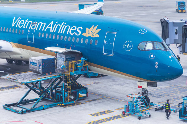 Vietnam Airlines aircraft loading air cargo containers before flight at Noi Bai international airport in Hanoi, Vietnam.