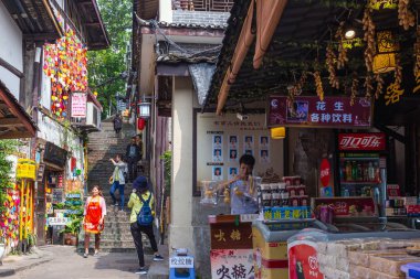 Turistler, 10 Mayıs 2019'da popüler bir seyahat noktası olan Ciqikou antik kentinde alışveriş için yürüyorlar, Chongqing, Çin.