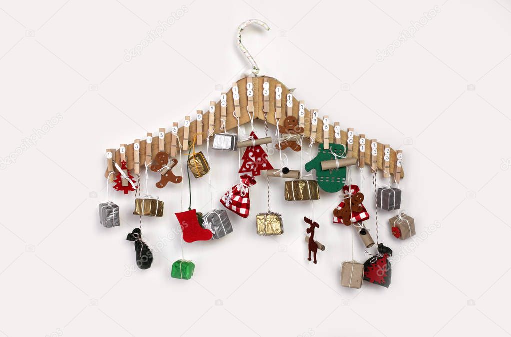 Christmas advent calendar with small gifts over white background, for candy or gifts in crafted bags and boxes. Christmas decoration for children, family winter holidays
