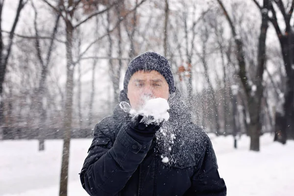 Średnim Wieku Człowiek Czarnym Płaszczu Dmuchanie Śniegu Jego Ramiona Zima — Zdjęcie stockowe