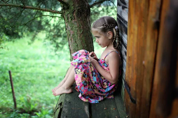 Niño lindo sentado solo en la casa del árbol en verano — Foto de Stock