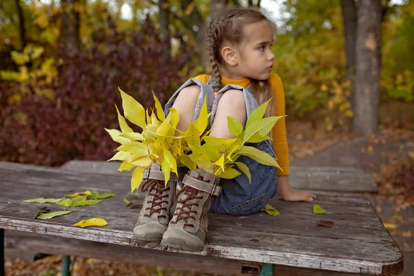 Cute girl in hipster style shoes with bright leaves inside — Stock Photo, Image