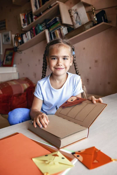 Девушка держит книгу с искусной бумажной закладкой — стоковое фото