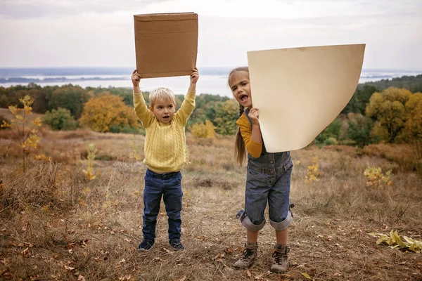 Маленькие дети держат плакат на фоне осени — стоковое фото