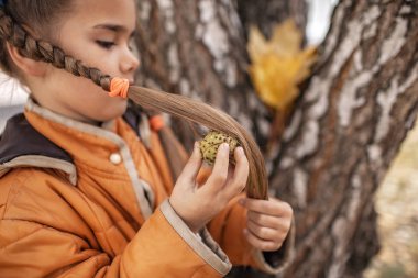 Sevimli liseli kız saçını gerçek kestaneyle tarıyor.