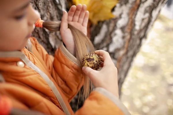 Cute schoolgirl is combing her hair with true chestnut — Stock Photo, Image