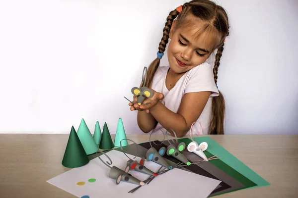 Sevimli 7-8 yaşındaki kız renkli kağıtlarla el yapımı fareler yapıyor. — Stok fotoğraf
