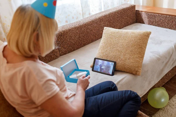 Happy grandmother celebrating birthday together with her family via internet in quarantine time, self-isolation and family values, online birthday party