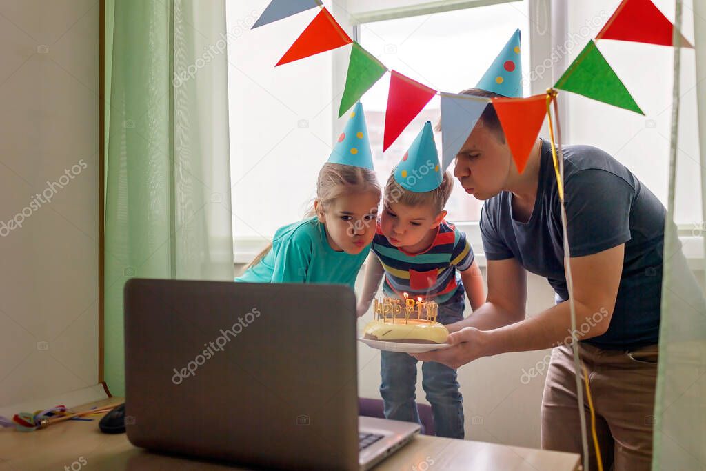 Happy family with two sibling celebrating birthday via internet in quarantine time, self-isolation and family values, online birthday party, selective focus on cake