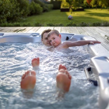 Yazlık evde aile hafta sonu, yerel tatil. Tatlı bir çocuk ve babası küvette dinleniyorlar sıcak bir günde, mutlu bir yaz tatili, açık hava yaşam tarzı.