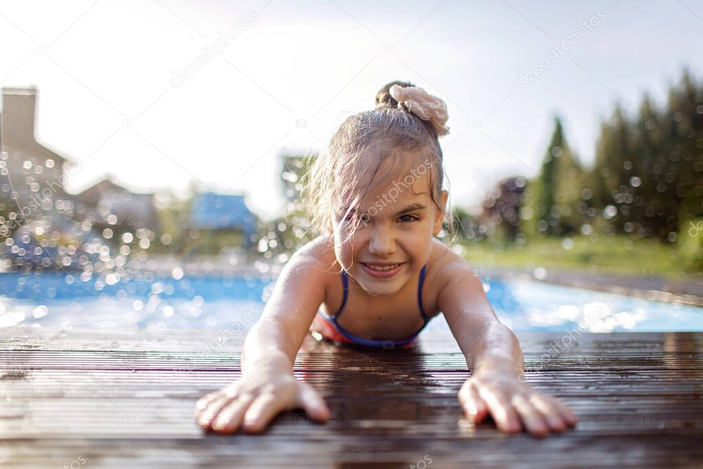 Family weekend in summer cottage, local staycation. Cute kid have a fun and cooling off in the swimming pool one hot day, happy summertime, outdoor lifestyle