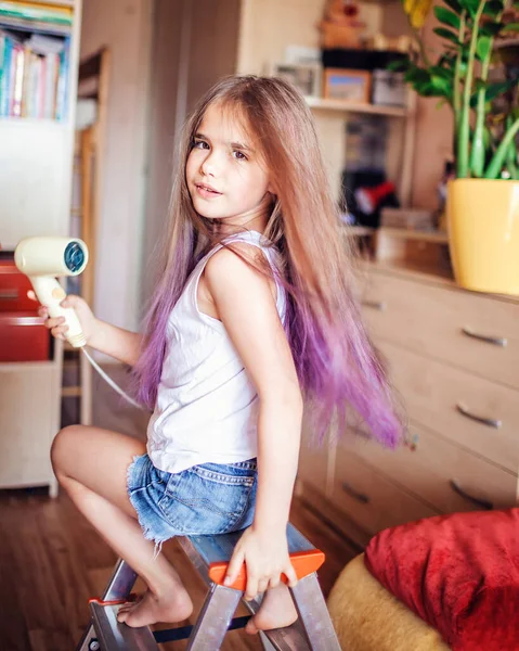 Beauty salon at home. First hair dye experience. Girl power. Cute 7-8 years old girl with long hair with gradient coloring hair effect, online courses, stay at home for coronavirus worldwide pandemic