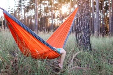 Sevimli 5 yaşındaki çocuk yerel tatilde vahşi ormanda hamakta dinleniyor, aile yaz tatili, sosyal uzaklık yaşam tarzı.