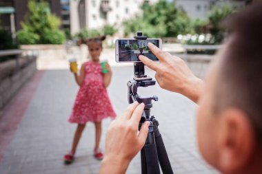 İnternetten para kazan. Aile kanalı, video blogcusu, internet kazancı ve uzaktan kumandalı serbest çalışma için kızıyla birlikte orta yaşlı bir baba film kaydediyor.