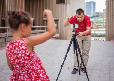 İnternetten para kazan. Aile kanalı, video blogcusu, internet kazancı ve uzaktan kumandalı serbest çalışma için kızıyla birlikte orta yaşlı bir baba film kaydediyor.