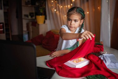 Noel ambalajı sıfır. Sevimli kız geleneksel Japon tarzı furoshiki 'yi internet üzerinden, online eğitim videosuyla paketlemeyi öğreniyor. Sürdürülebilir kutlama