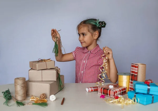 Diy装飾 かわいい女の子は プラスチック製の弓と自然素材 松の針 枝や柑橘類のスライスと自家製包装で一般的なラップボックスの間で選択を行う ゼロ廃棄物の休日 — ストック写真