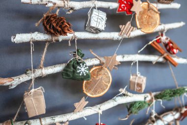 Alternatif Noel ağacı donmuş dallarla yapılmış ve küçük ekolojik oyuncaklar ve kağıt çelenklerle süslenmiş, sıfır atık bayramı, sıfır atık ve plastiksiz tatil