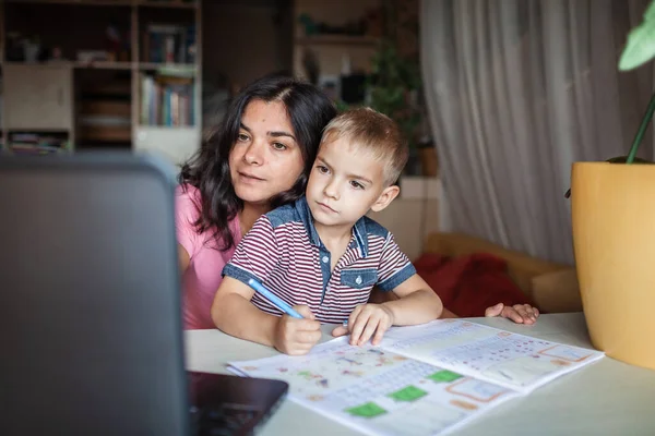遠くの教育だ ヨーロッパの母親は自宅で彼女の小さな息子とオンライン宿題をしています 隔離中の社会的距離 遠隔授業 屋内家族のライフスタイル — ストック写真