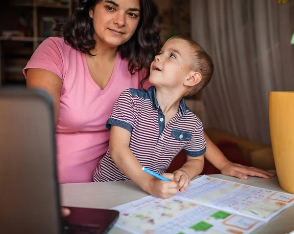 遠くの教育だ ヨーロッパの母親は自宅で彼女の小さな息子とオンライン宿題をしています 隔離中の社会的距離 遠隔授業 屋内家族のライフスタイル — ストック写真