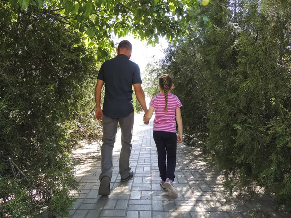Baba ve kız parkta yürüyor