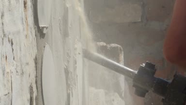 Yıkıcı çekiçli işçi iç duvarı yıkıyor.