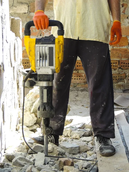 Yıkıcı çekiçli işçi iç duvarı yıkıyor.