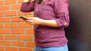 Kadın satırı müzik uygulaması ile sokakta müzik dinler.