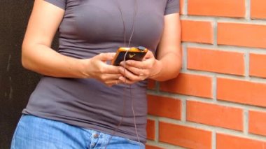 Kadın satırı müzik uygulaması ile sokakta müzik dinler.