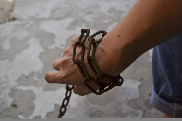 A womans hand wrapped in a chain