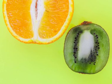 Kivi ve turuncu meyve sarı-yeşil zemin üzerine