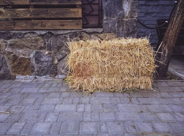 Samanlık kentsel kaldırım döşeme üzerinde yatıyor. Köy şehir.