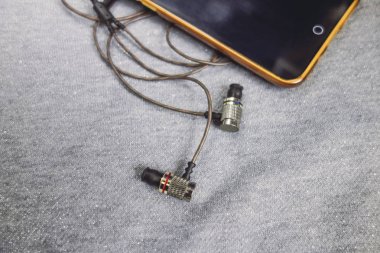 Parlak gümüş arka plan üzerinde kulaklık ile sarı telefon.