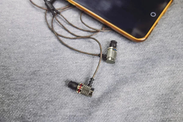 Parlak gümüş arka plan üzerinde kulaklık ile sarı telefon.