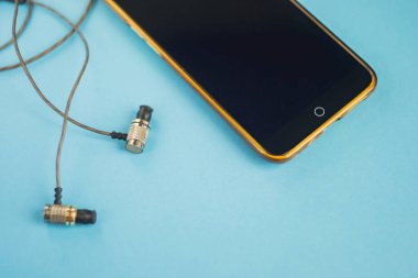 Sarı telefon ile mavi bir arka plan üzerinde kulaklık.