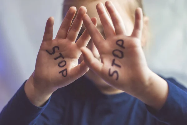 Kleines verängstigtes Mädchen zeigt das Wort Stop, das auf dem Arm steht. Kinder sind Gewalt und Veröffentlichung im häuslichen und schulischen Konzept und den Rechten der Kinder ausgesetzt. — Stockfoto