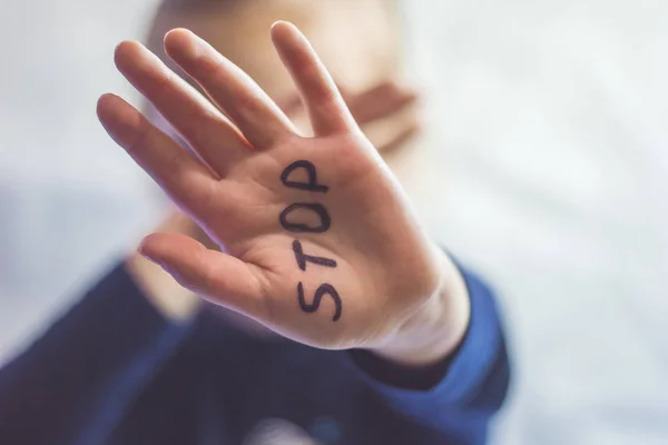 Kleines verängstigtes Mädchen zeigt das Wort Stop, das auf dem Arm steht. Kinder sind Gewalt und Veröffentlichung im häuslichen und schulischen Konzept und den Rechten der Kinder ausgesetzt. — Stockfoto