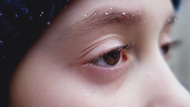 Gotas de la lluvia en las pestañas y cejas de una niña . — Vídeos de Stock